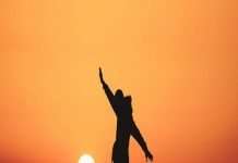 man standing on rock silhoutte photo