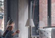 cropped-woman-sitting-on-gray-sofa-chair-holding-mug-photo.jpg