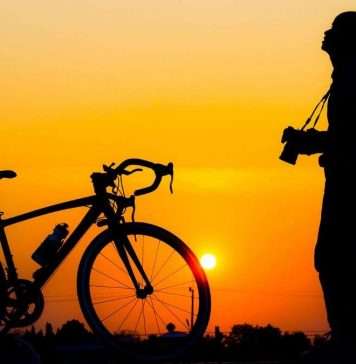 man standing besides a cycle