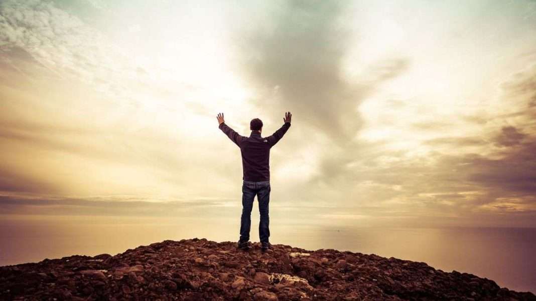 man standing under orange sky calling god